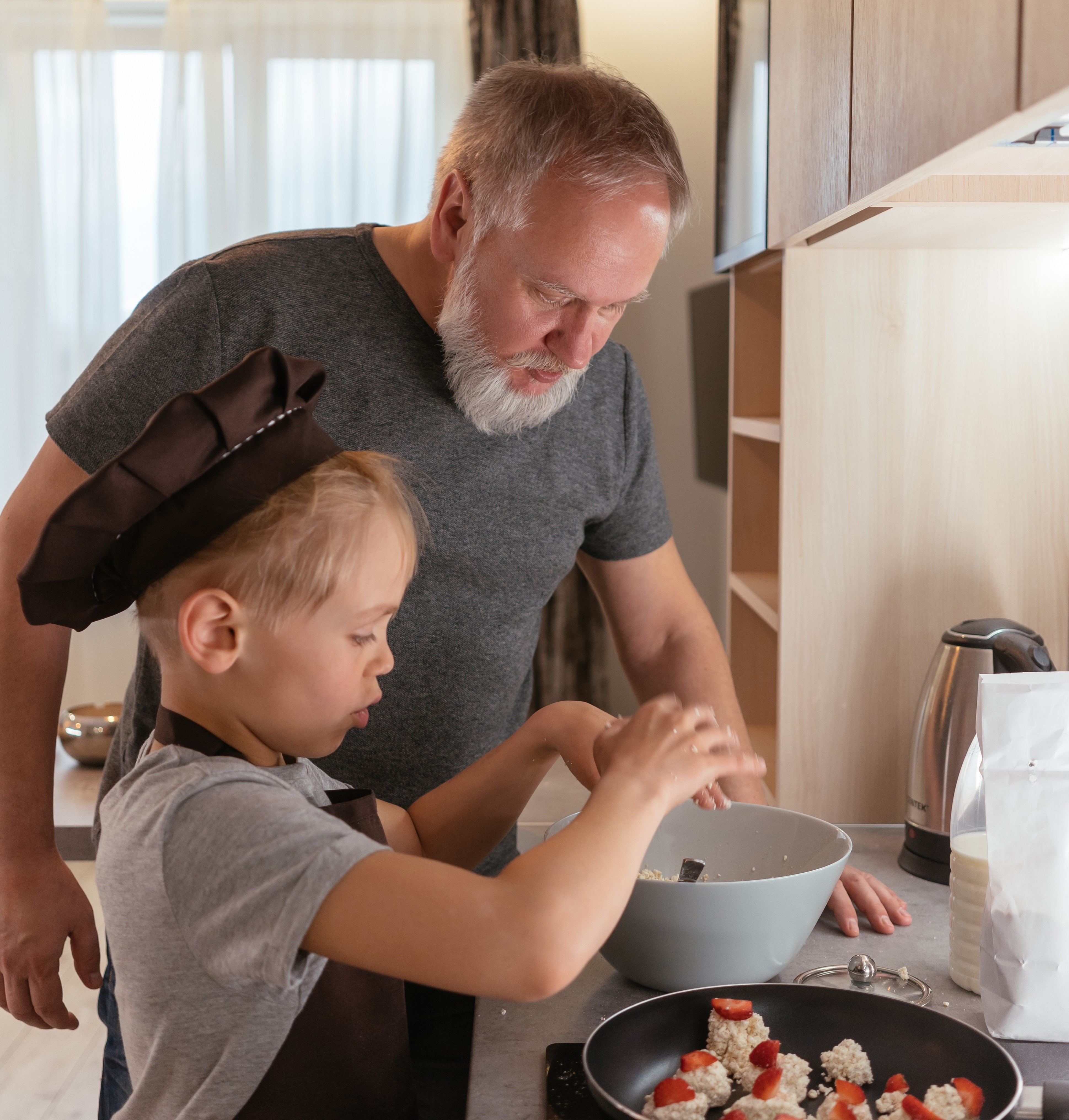 image of Grandfather cooking with grandson